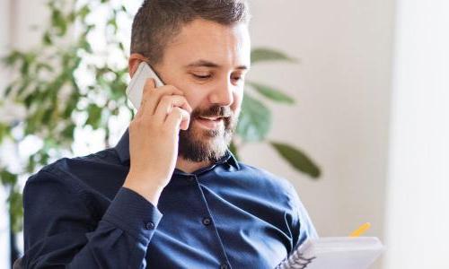 IT Manager Discussing Team Strategy On Phone In Office 