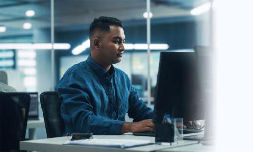 Software Developer Seated at Computer Desk In Office 